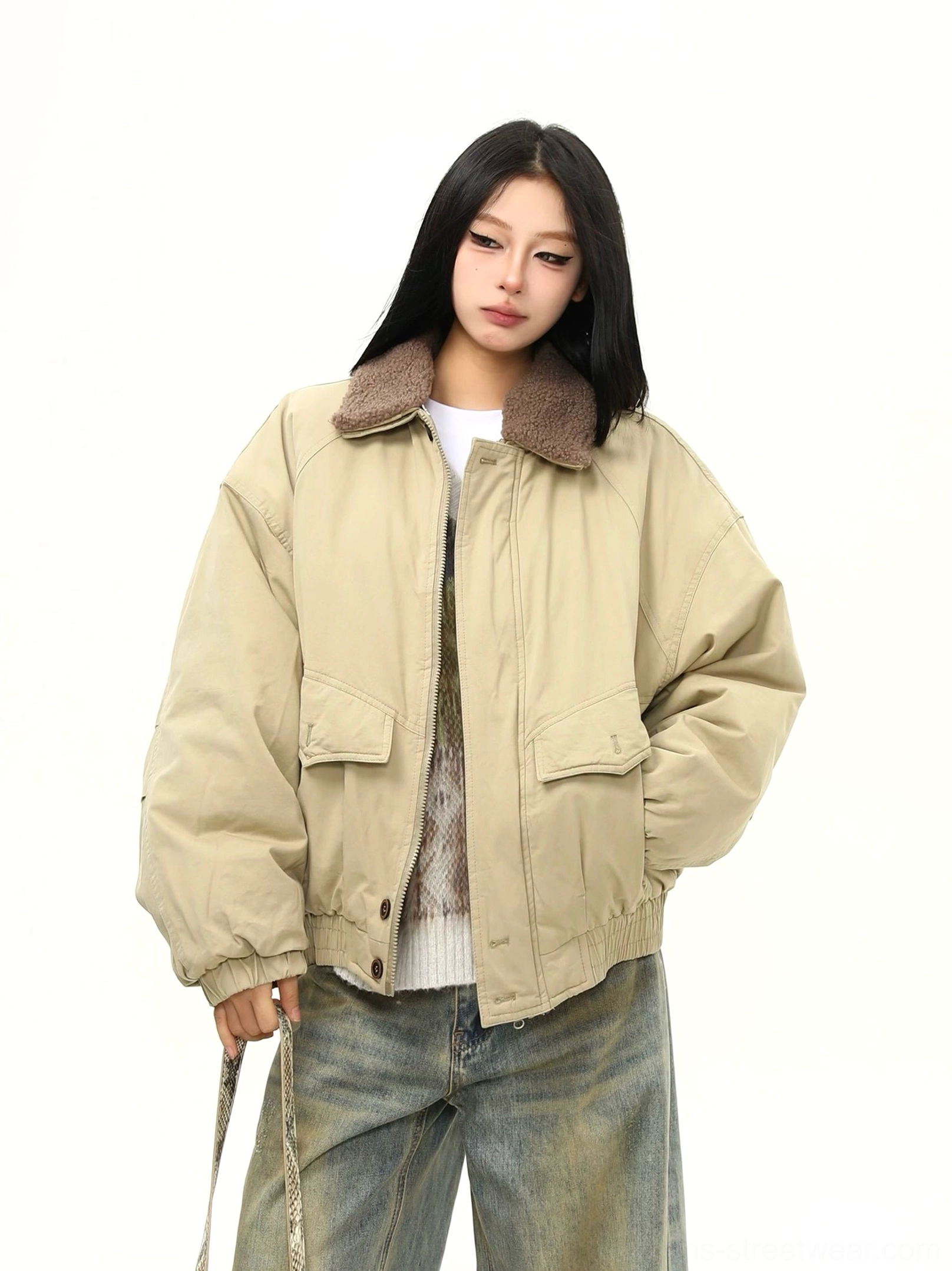 Women wearing a khaki oversized sherpa collar bomber jacket with padded body, utility flap pockets, wide leg jeans, and layered winter streetwear styling