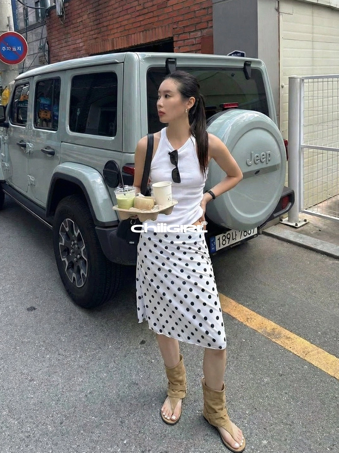 Khaki open toe suede slouchy sandal ankle boots styled with polka dot midi skirt on urban street