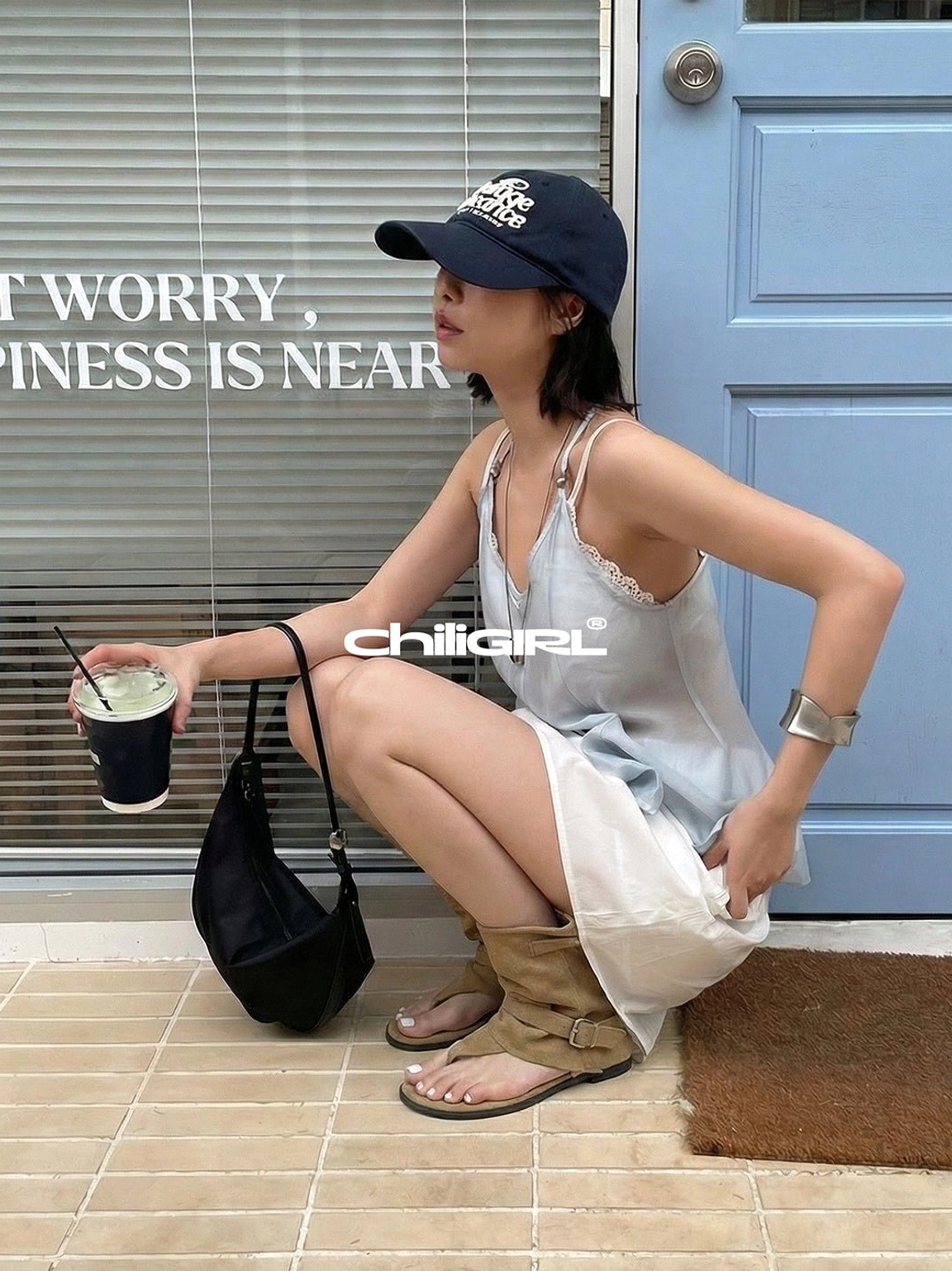 Khaki slouchy thong toe suede sandal ankle boots styled with satin camisole and white skirt outdoors