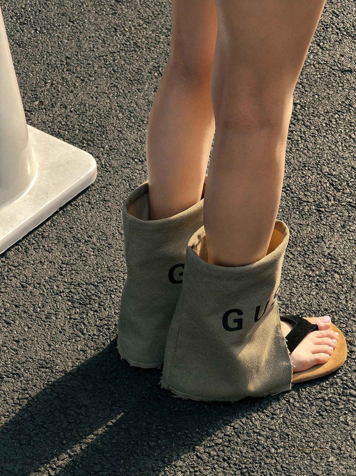 Rear view of khaki split-toe western sandal boots showing the relaxed shaft, tan suede sole, and open warm-weather construction