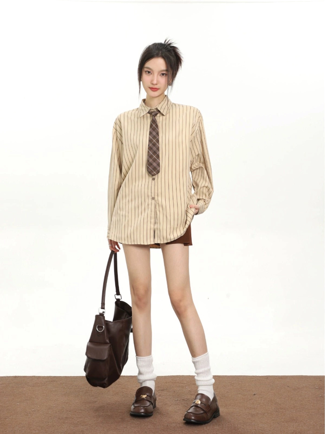 Khaki striped women's button-up shirt styled with brown mini shorts loafers white socks and leather tote