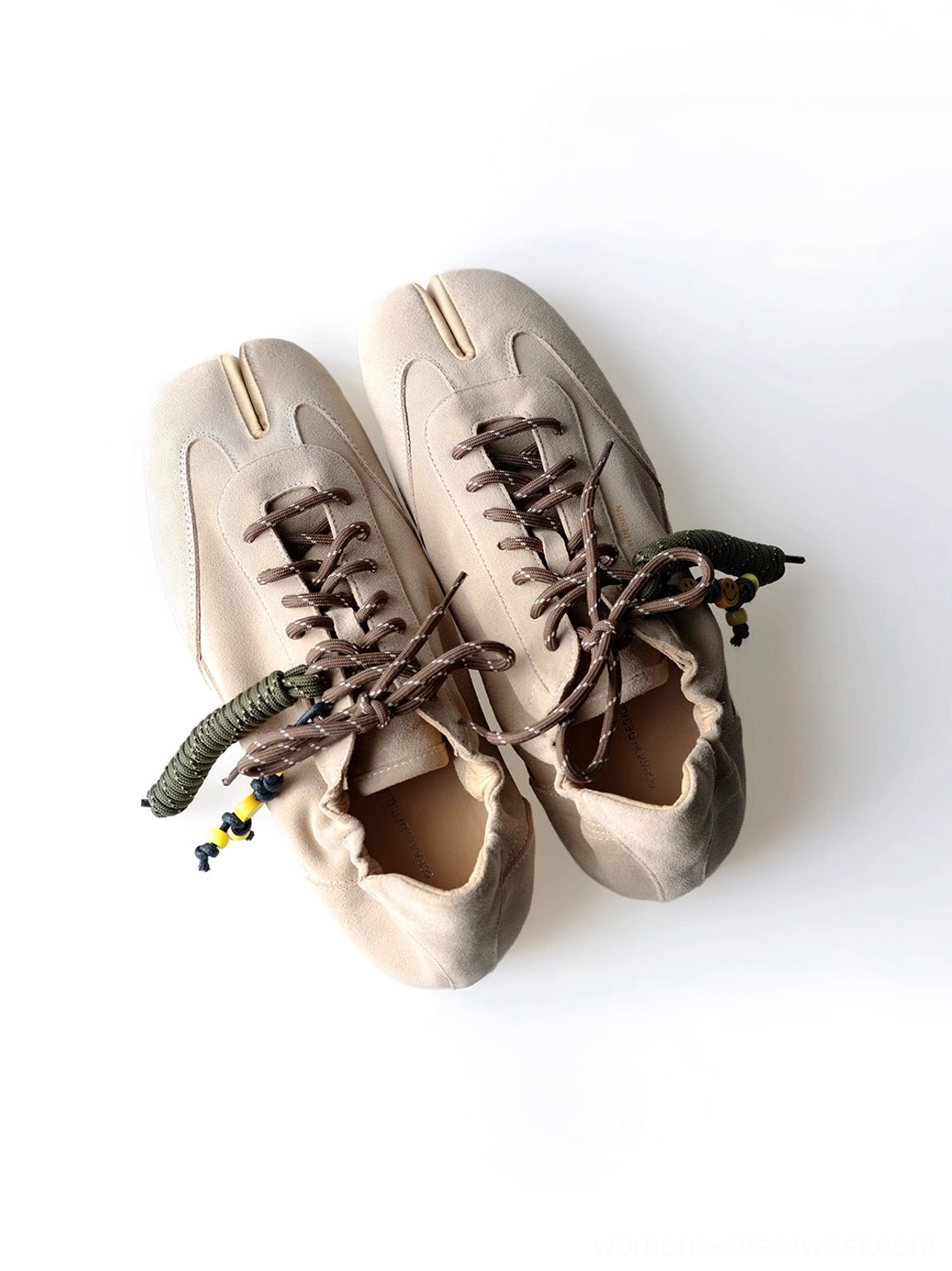 Inner side view of khaki suede tabi sneakers showing low-profile outsole, soft upper, and shoe interior