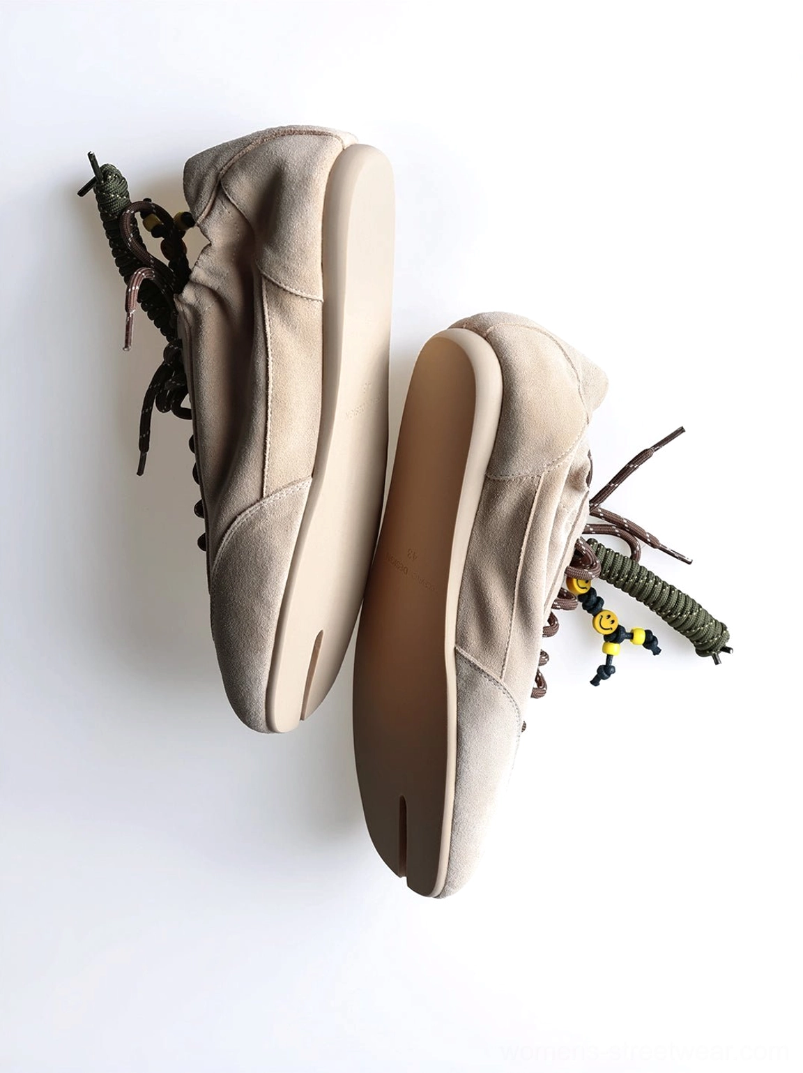 Top-down side profile of khaki suede tabi sneakers with thin flat soles and decorative bead lace details