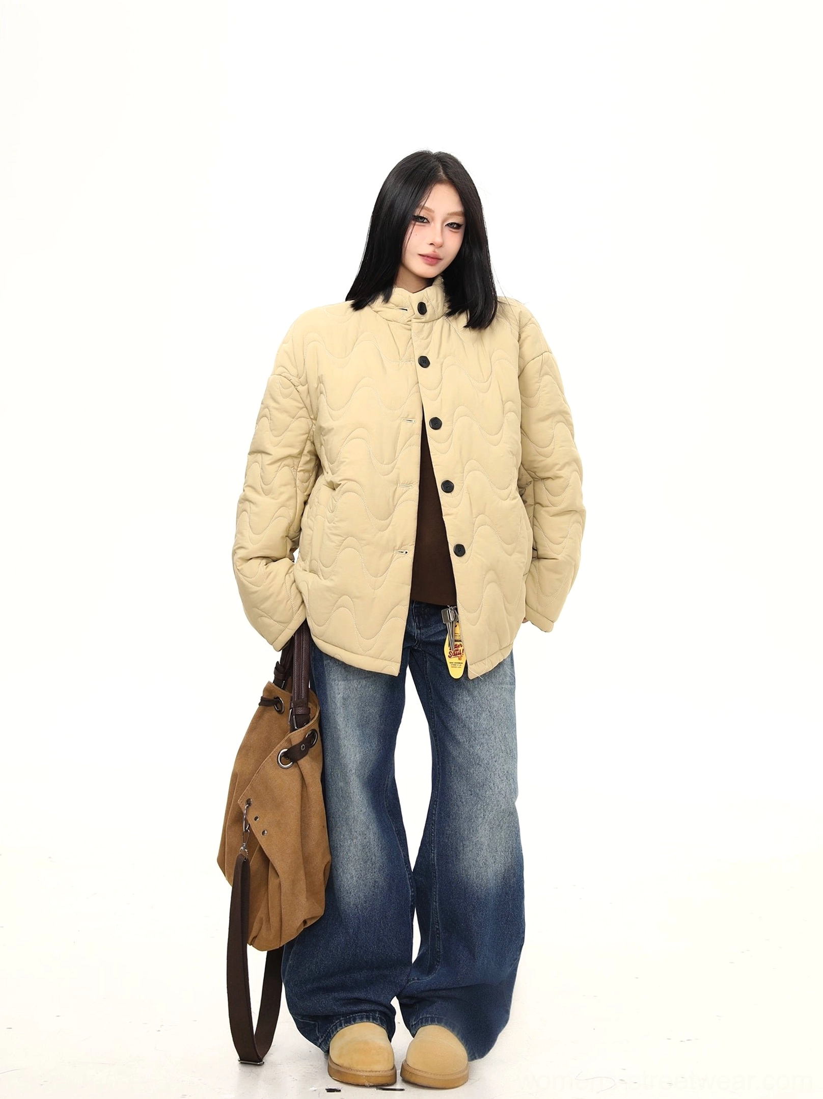 Three-quarter view of khaki wavy quilted stand-collar jacket showing textured quilting and oversized streetwear fit