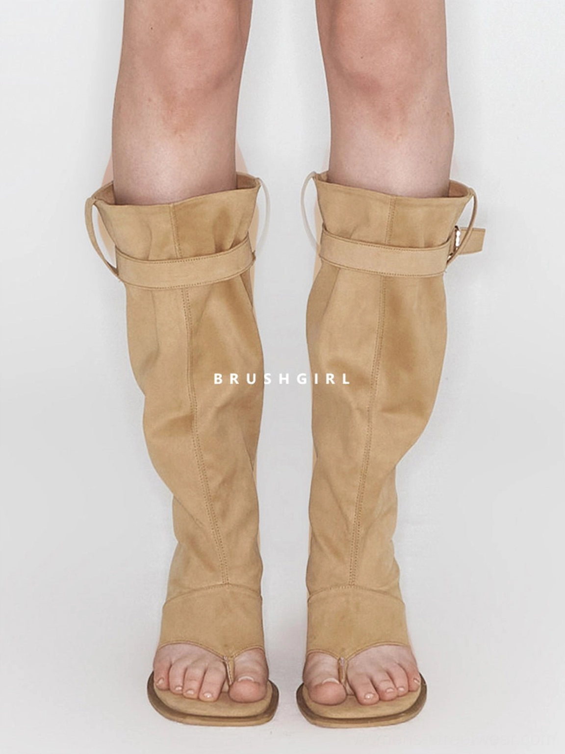 Front view of khaki knee-high thong sandal boots worn with a relaxed slouchy shaft and flat sole