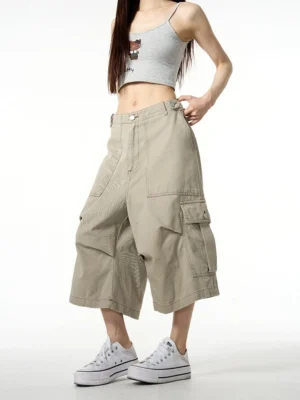 Front view of khaki wide-leg cropped cargo pants styled with a gray cropped camisole and white canvas sneakers