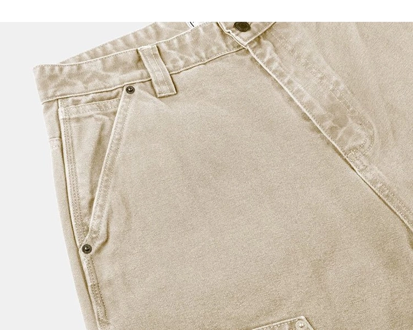 Khaki women's carpenter streetwear pants side pocket close-up showing rivet reinforcement and textured cotton fabric