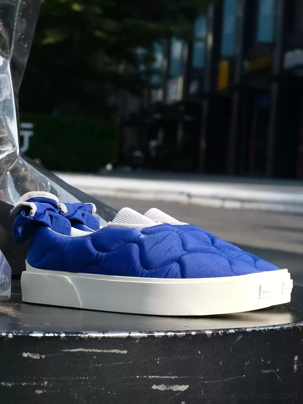 Klein blue quilted slip-on skate shoes styled on an urban curb with thick white rubber platform sole