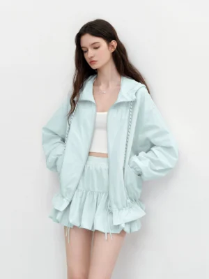 Mint green Korean streetwear hooded windbreaker and ruffle bubble mini skirt set shown on a model in a front three quarter studio view