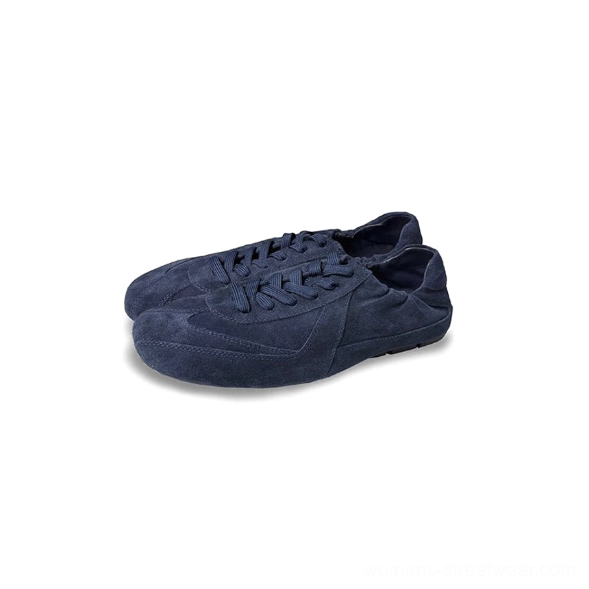 Lace-up suede sneakers with a softly gathered heel opening, flat outsole, and understated contemporary profile