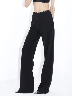 Black lace waist high-rise wide-leg streetwear trousers side full-body view in white studio