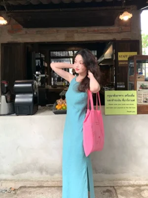 Lake blue sleeveless side slit ramie lyocell maxi dress in a three-quarter side view at a retro cafe