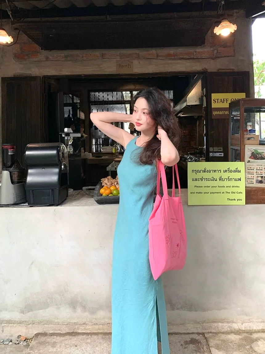 Lake blue sleeveless side slit ramie lyocell maxi dress in a three-quarter side view at a retro cafe