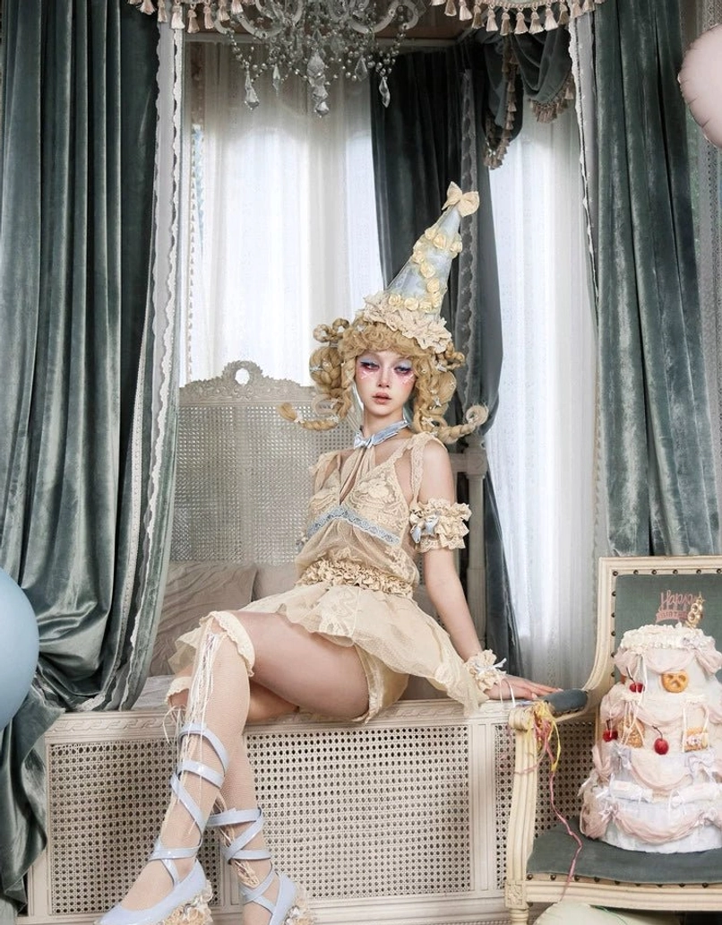 Side view of a layered lace tulle mini skirt in a vintage lolita outfit with beige mesh volume, lace leg accessories, and wrist cuffs