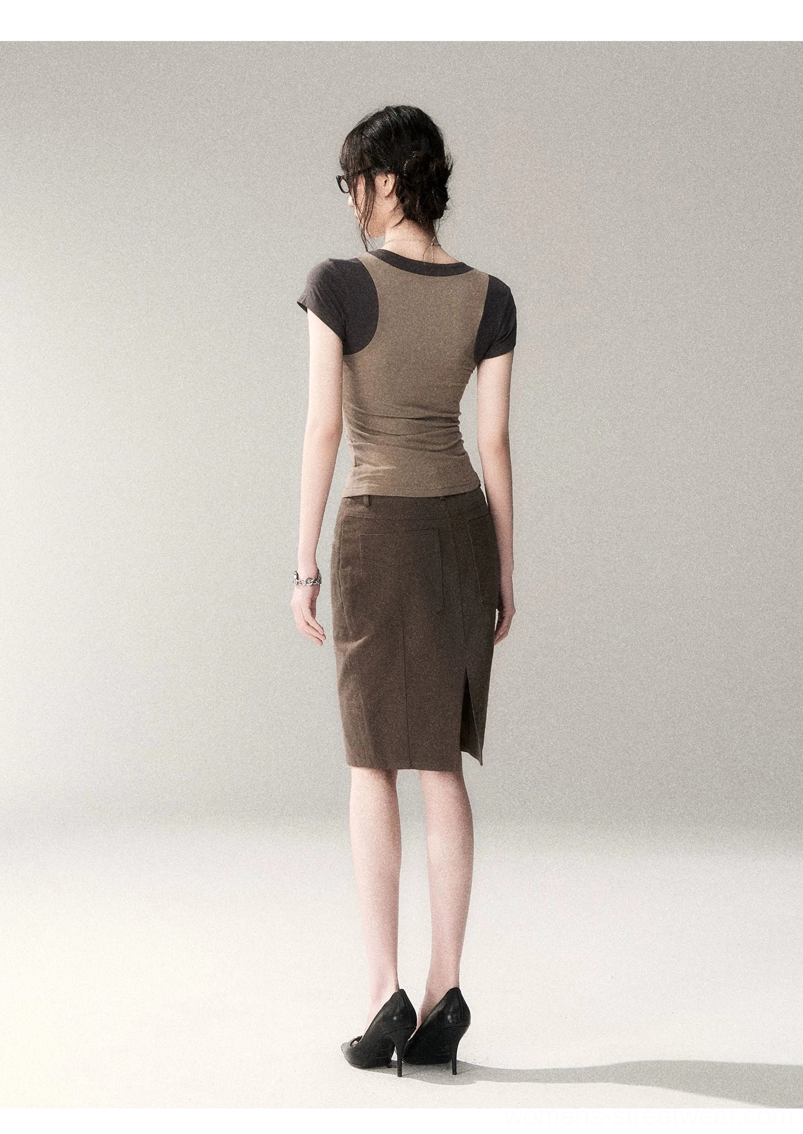 Back view of a layered two-tone scoop neck streetwear top with contrast upper-back panel, brown midi skirt, and black high heel pumps