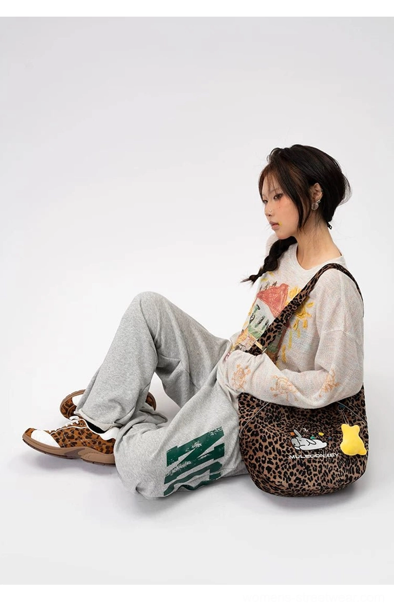 Model wearing leopard bunny hobo shoulder bag with adjustable animal print strap in a casual streetwear outfit