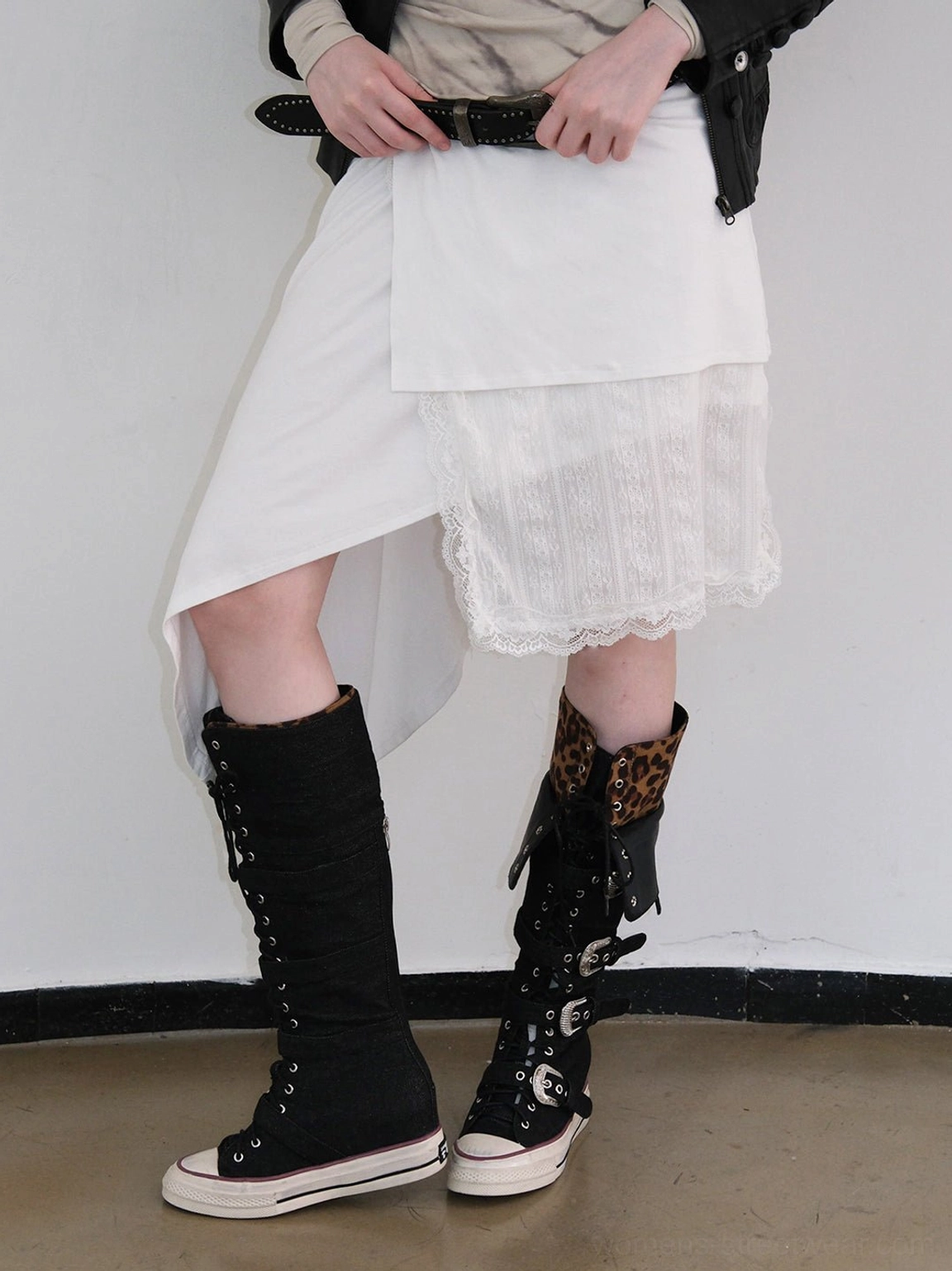Front view of leopard cuff buckle knee-high canvas streetwear boots paired with an asymmetric white skirt