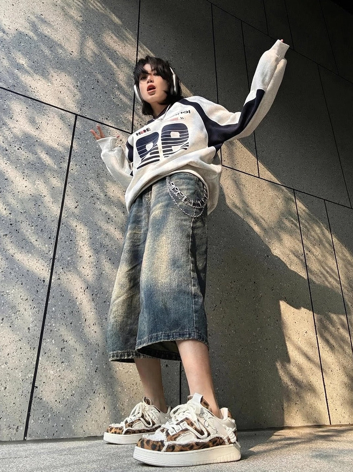 Front view of leopard deconstructed platform sneakers styled with graphic oversized streetwear, cropped denim jeans, white socks, and a bold Y2K-inspired casual outfit