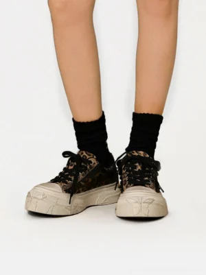 Front on-foot view of leopard print distressed platform canvas sneakers styled with black crew socks