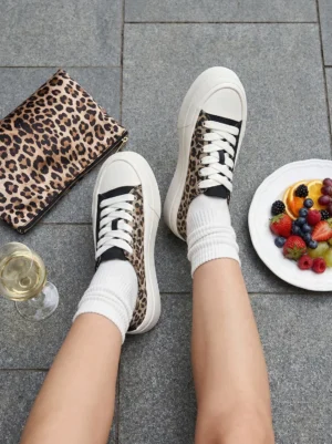 Overhead view of leopard print platform canvas sneakers styled with white crew socks and a matching leopard accessory for a casual Y2K streetwear outfit