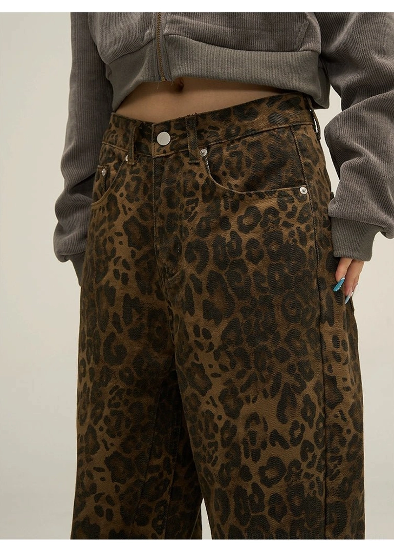 Close-up of leopard print wide leg streetwear pants showing the structured waistband, button fly, belt loops, and pocket details
