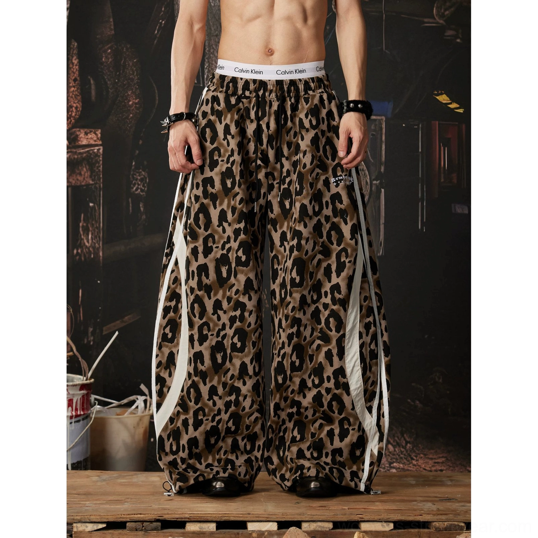 Full front view of leopard print wide leg track pants with double white stripes elastic waist and gathered drawstring cuffs