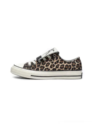 Single leopard print canvas sneaker with white rubber toe cap and foldable spider graphic tongue on a clean white background