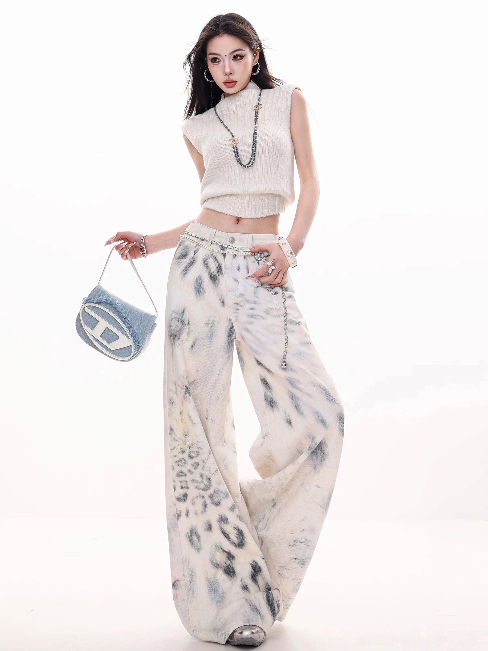 Three-quarter view of relaxed leopard print tie-dye wide-leg jeans with natural waist, flowing denim drape, and visible waist chain styling