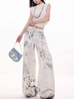 Front view of off-white leopard tie-dye wide-leg jeans styled with a cropped tank top, silver jewelry, and a blue underarm bag in a Seoul streetwear outfit
