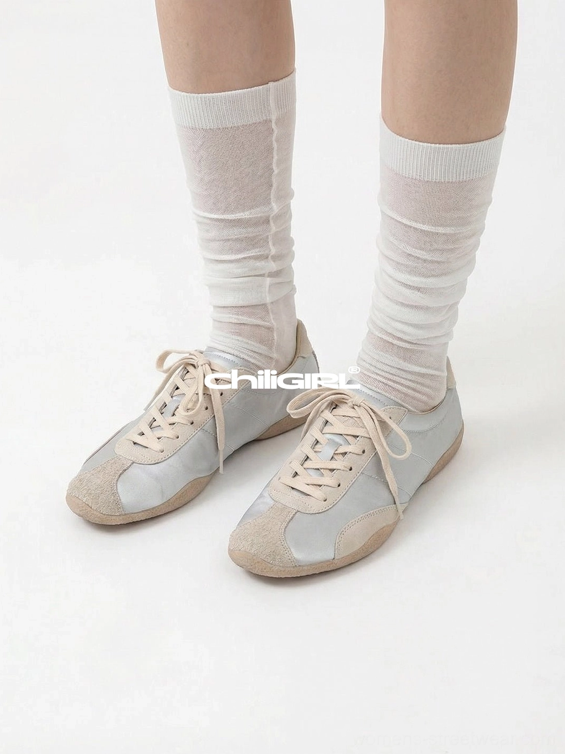 Light beige retro lace-up sneakers styled with sheer white pleated mid-calf socks in a clean studio close-up showing the low-top silhouette