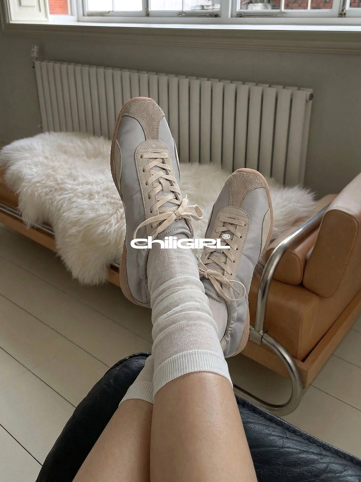 Light beige retro streetwear trainers worn with sheer white mid-calf socks in a relaxed vintage apartment setting
