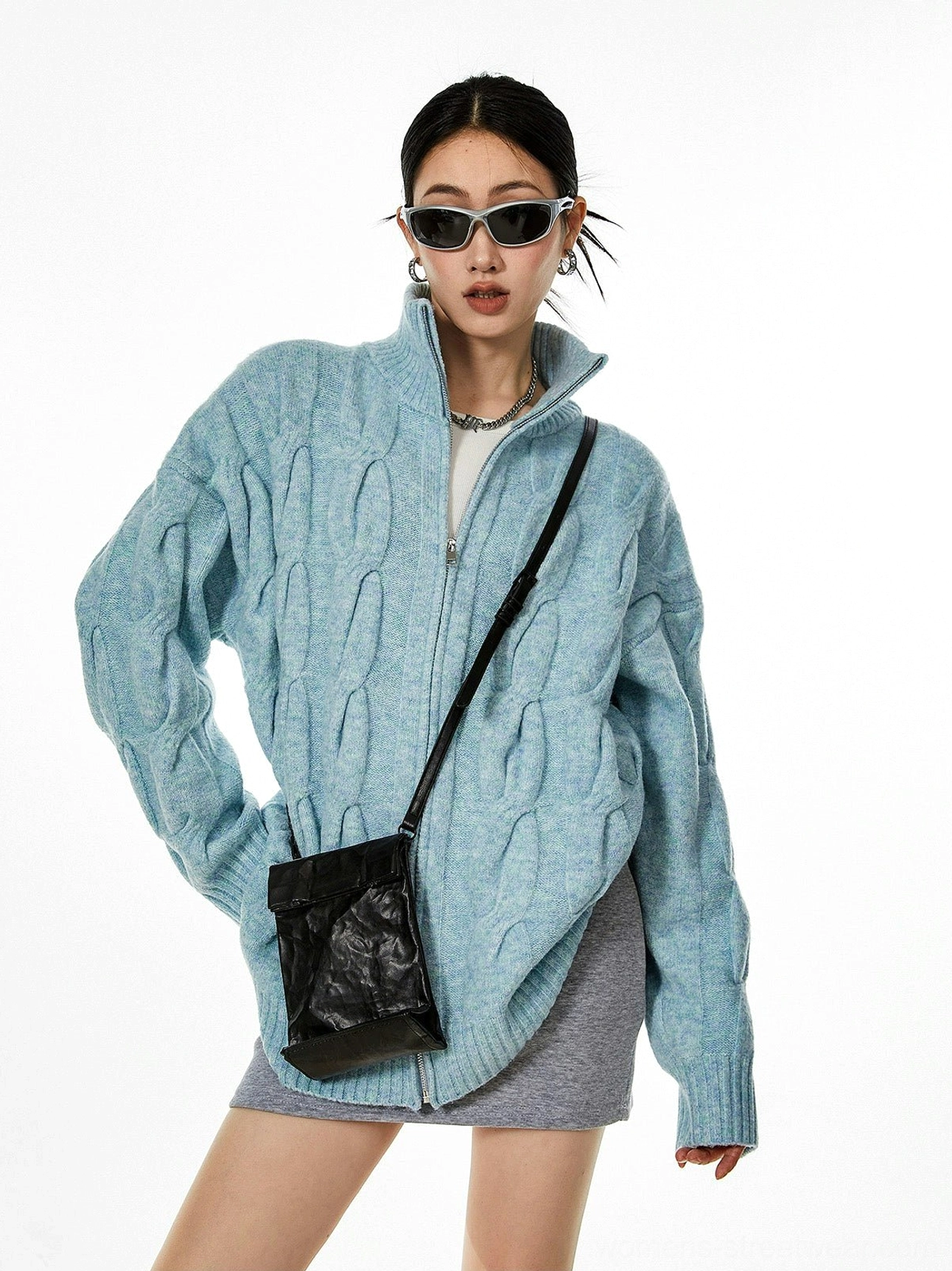 Light blue cable knit zip-up cardigan three quarter view stand collar zipper closure