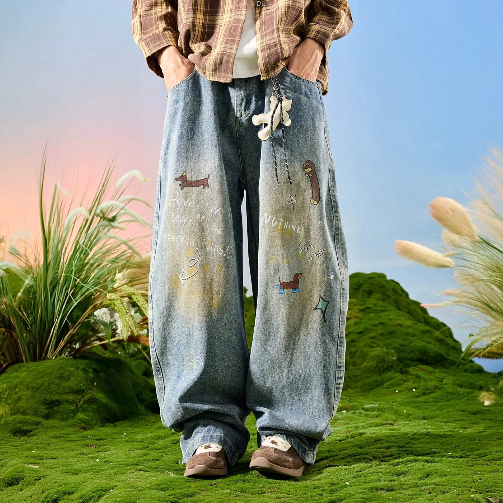 Front full-body view of light blue faded doodle wide leg jeans with sausage dog graphics handwritten artwork and detachable plush pendant