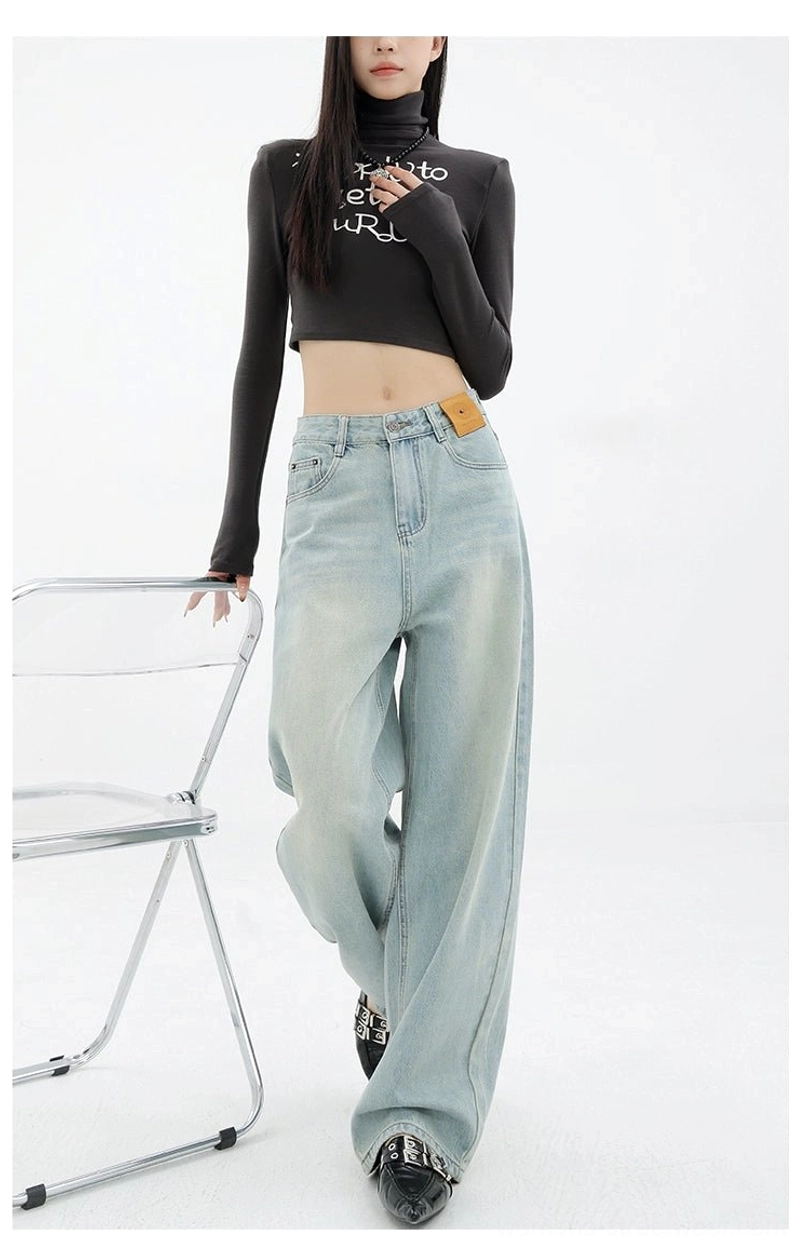 Light blue faded wide-leg denim jeans shown in motion with a black cropped turtleneck and pointed shoes in a modern Seoul fashion outfit