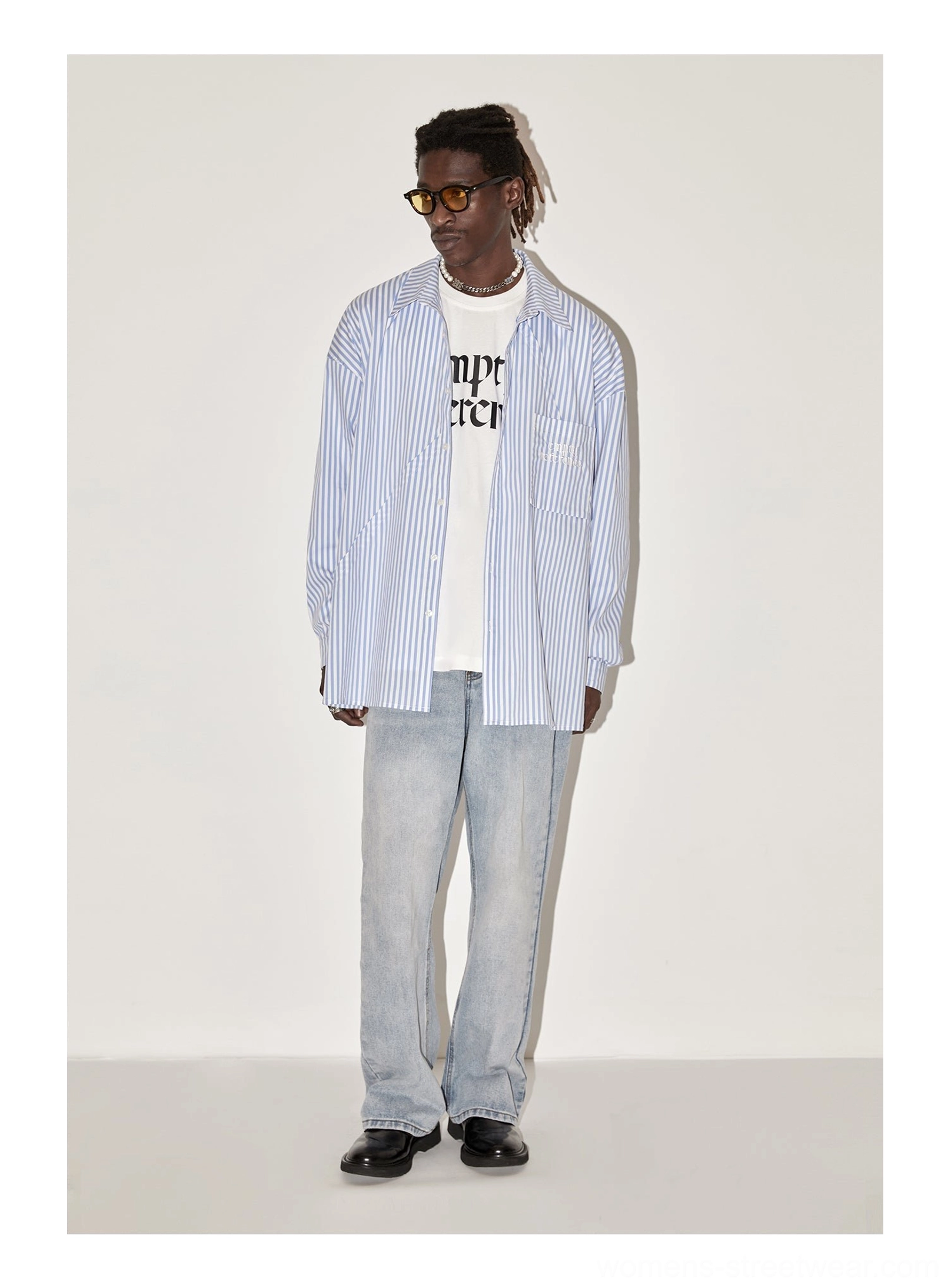 Front view of male model wearing light blue geometric panel striped oversized unisex button-up shirt