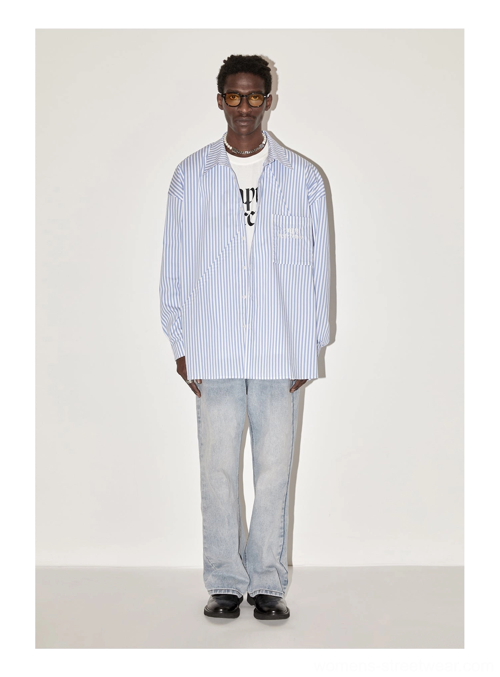Full body male streetwear outfit with light blue geometric panel striped oversized shirt graphic tee and jeans
