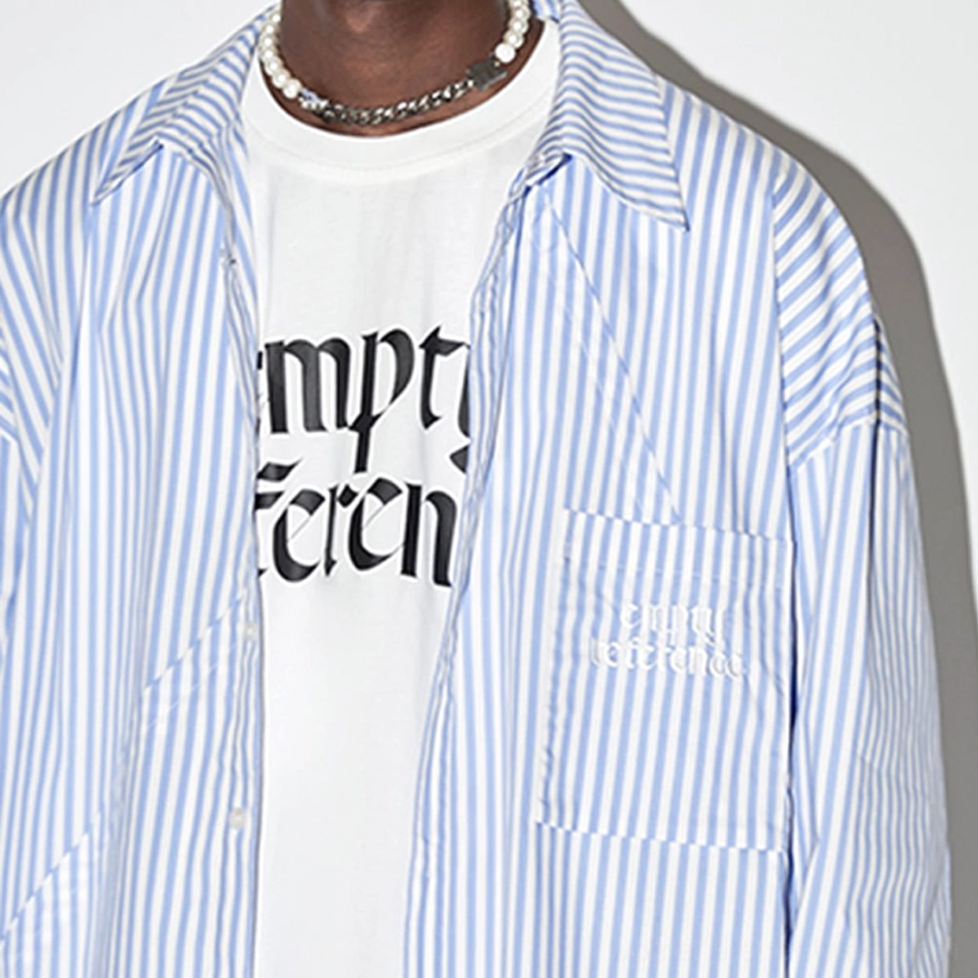 Close-up of light blue geometric panel striped oversized shirt showing diagonal stripe construction chest pocket and buttons