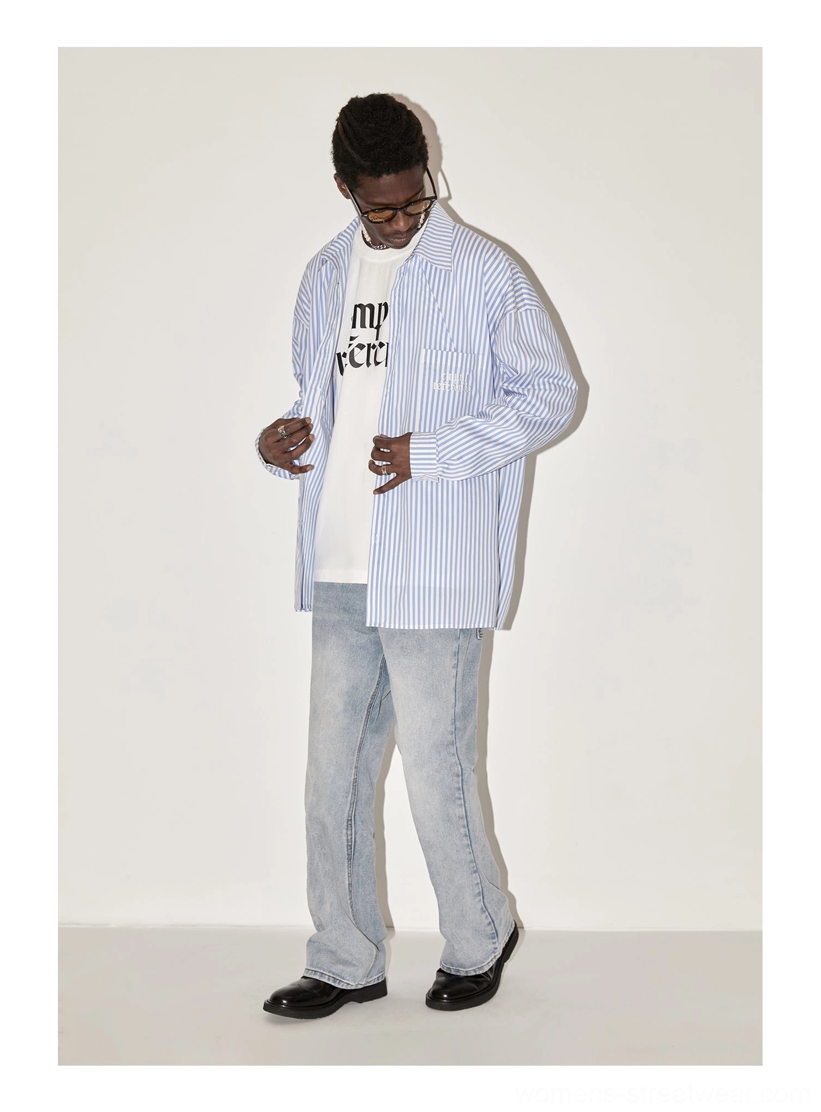 Side view of light blue geometric panel striped oversized streetwear shirt styled with light wash denim