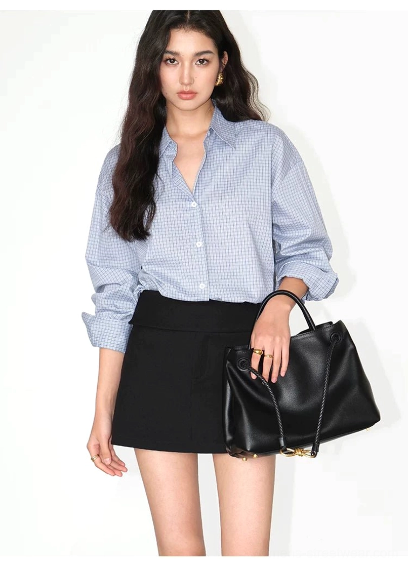 Light blue gingham oversized button-up shirt styled half tucked with black mini skirt and handbag