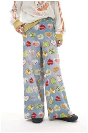 Front view of light blue heart print wide leg pants with colorful graphic slogans styled with an oversized sweatshirt