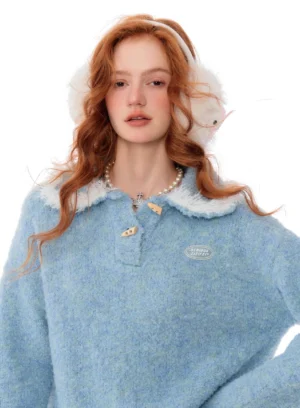 Close-up of light blue Korean streetwear knit sweater with white faux fur collar, golden toggle closure, and chest patch detail