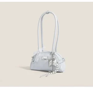 Light blue faux leather half-moon baguette shoulder bag with lace bow pendant and silver-tone hardware angled view