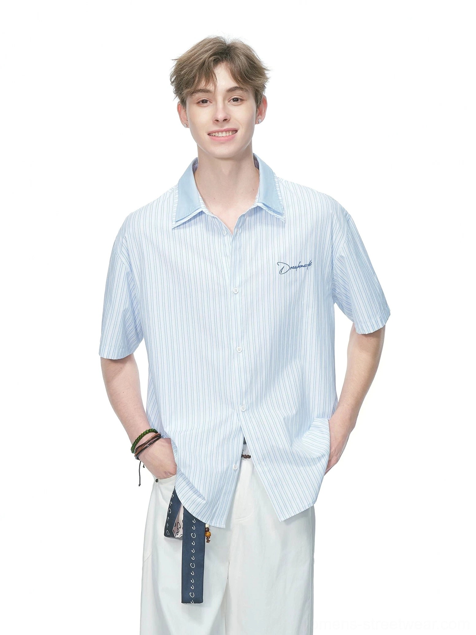 Light blue vertical pinstripe short sleeve button shirt with relaxed loose fit and subtle chest embroidery styled with white wide leg pants