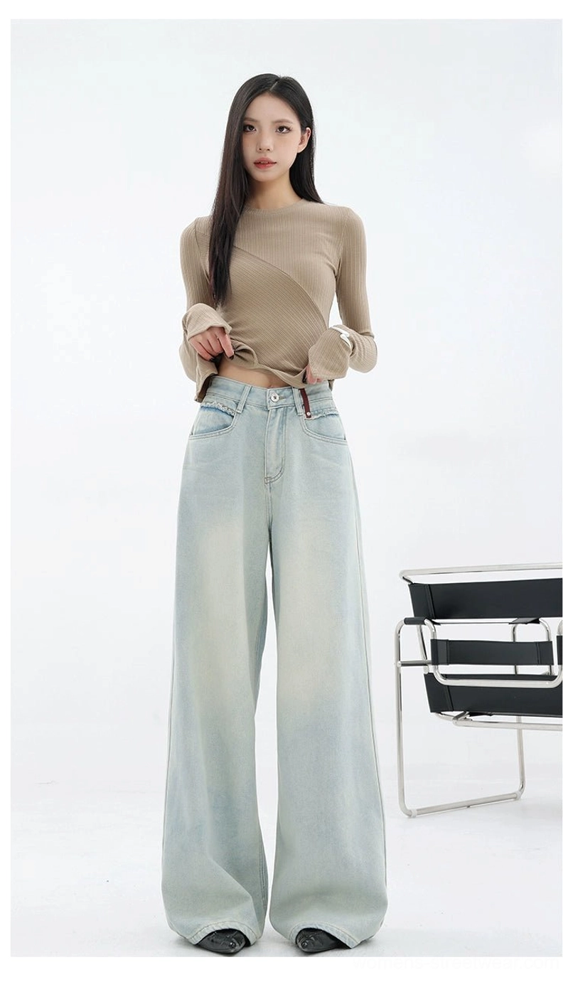 Front view of relaxed light blue wide-leg denim jeans styled with a cropped neutral long-sleeve top