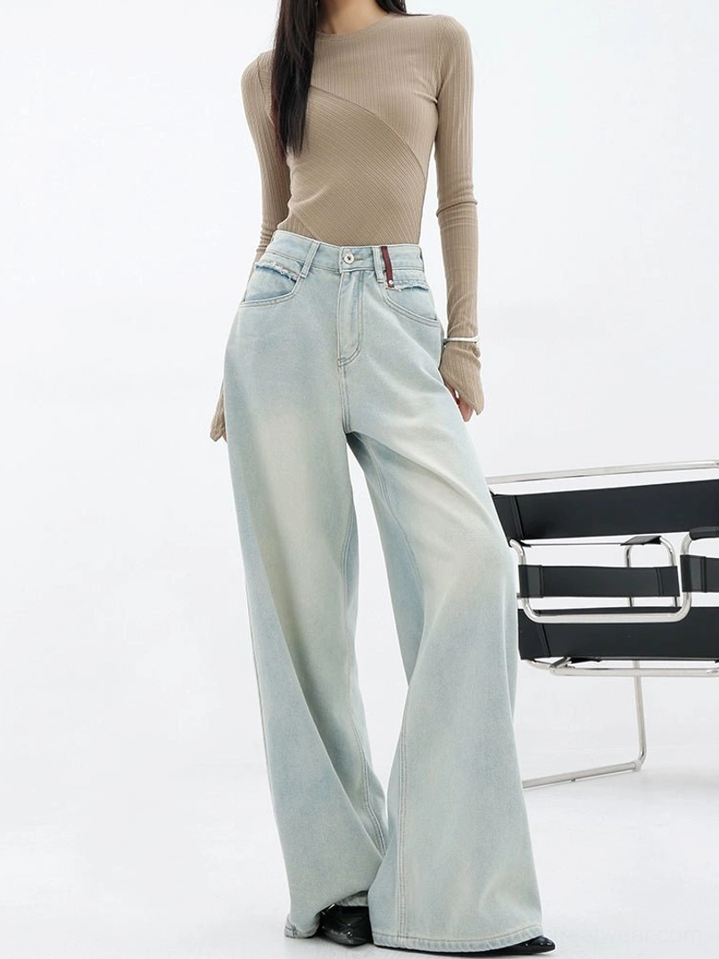Front three-quarter view of women wearing relaxed light blue wide-leg streetwear pants with a classic denim waistband