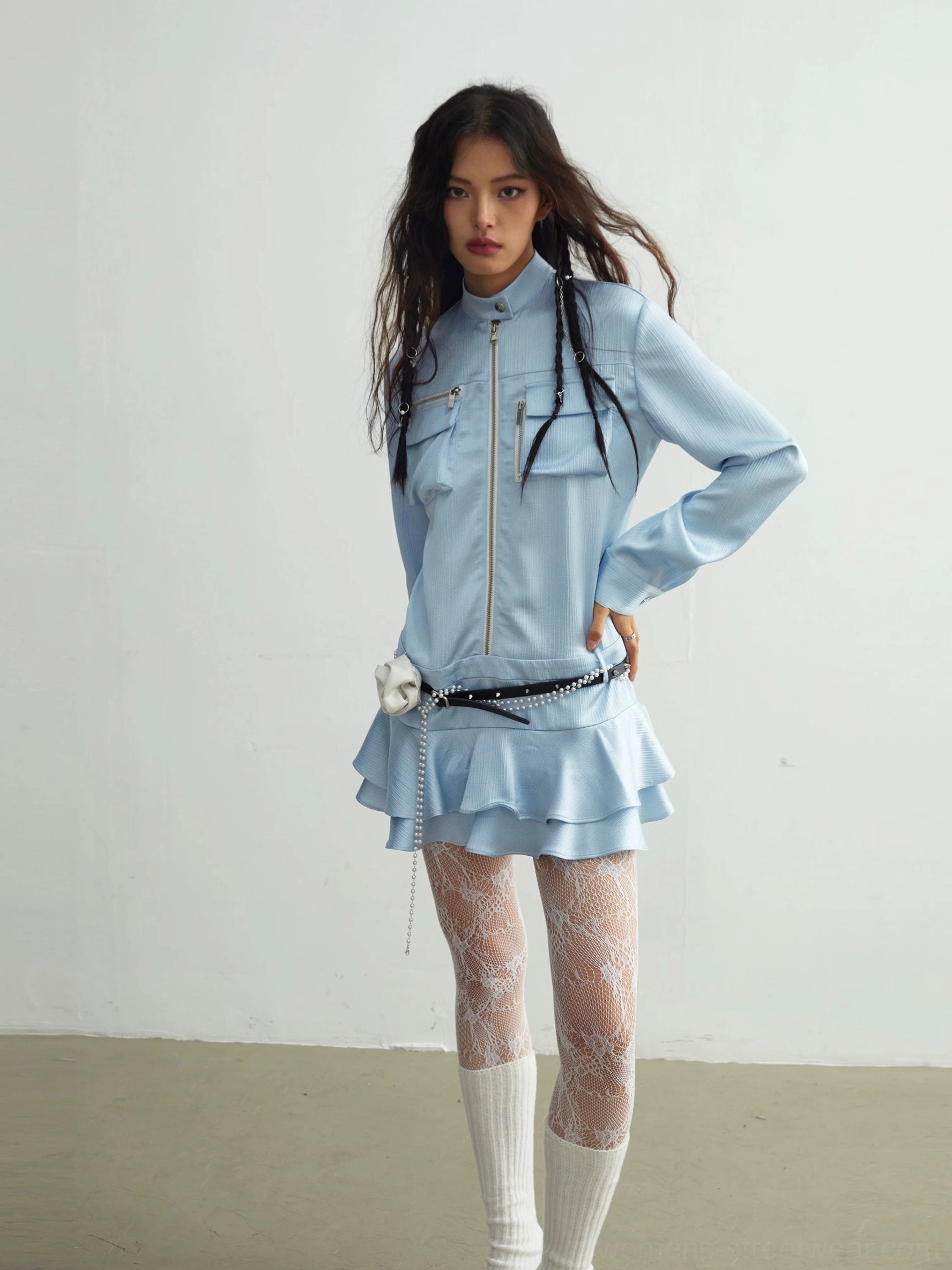 Light blue ruffle mini shirt dress styled with white knee-high socks, lace tights, pearl waist belt, and sculpted white flower accessory