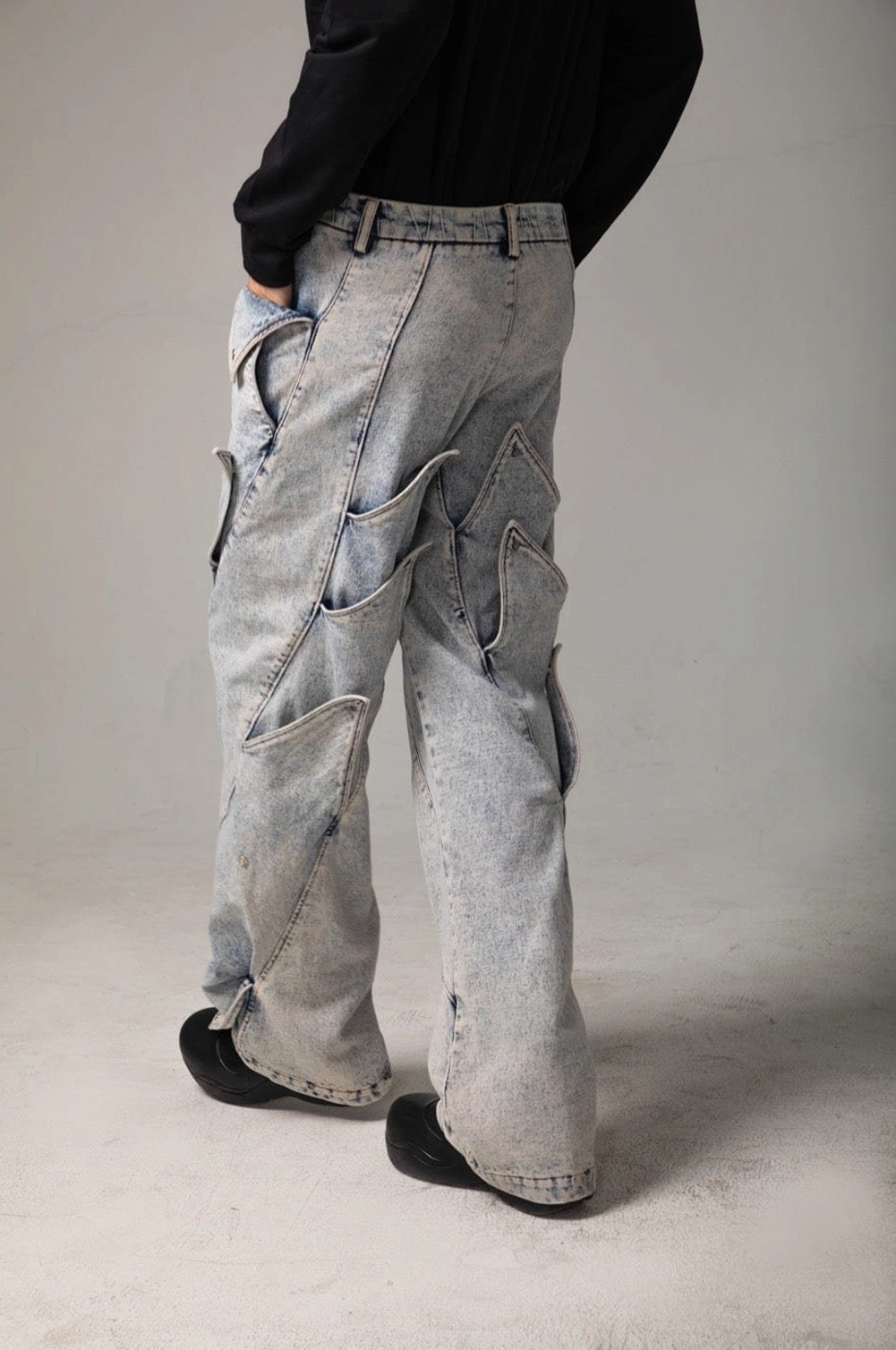 Rear three quarter view of light blue shark fin jeans with back panels, side details, and classic denim waistband