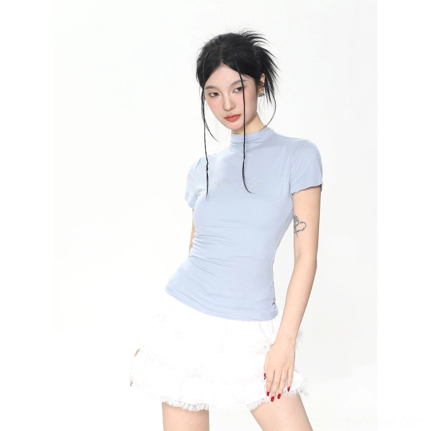 Light blue fitted mock neck short sleeve baby tee for women styled with a white ruffle skirt in studio