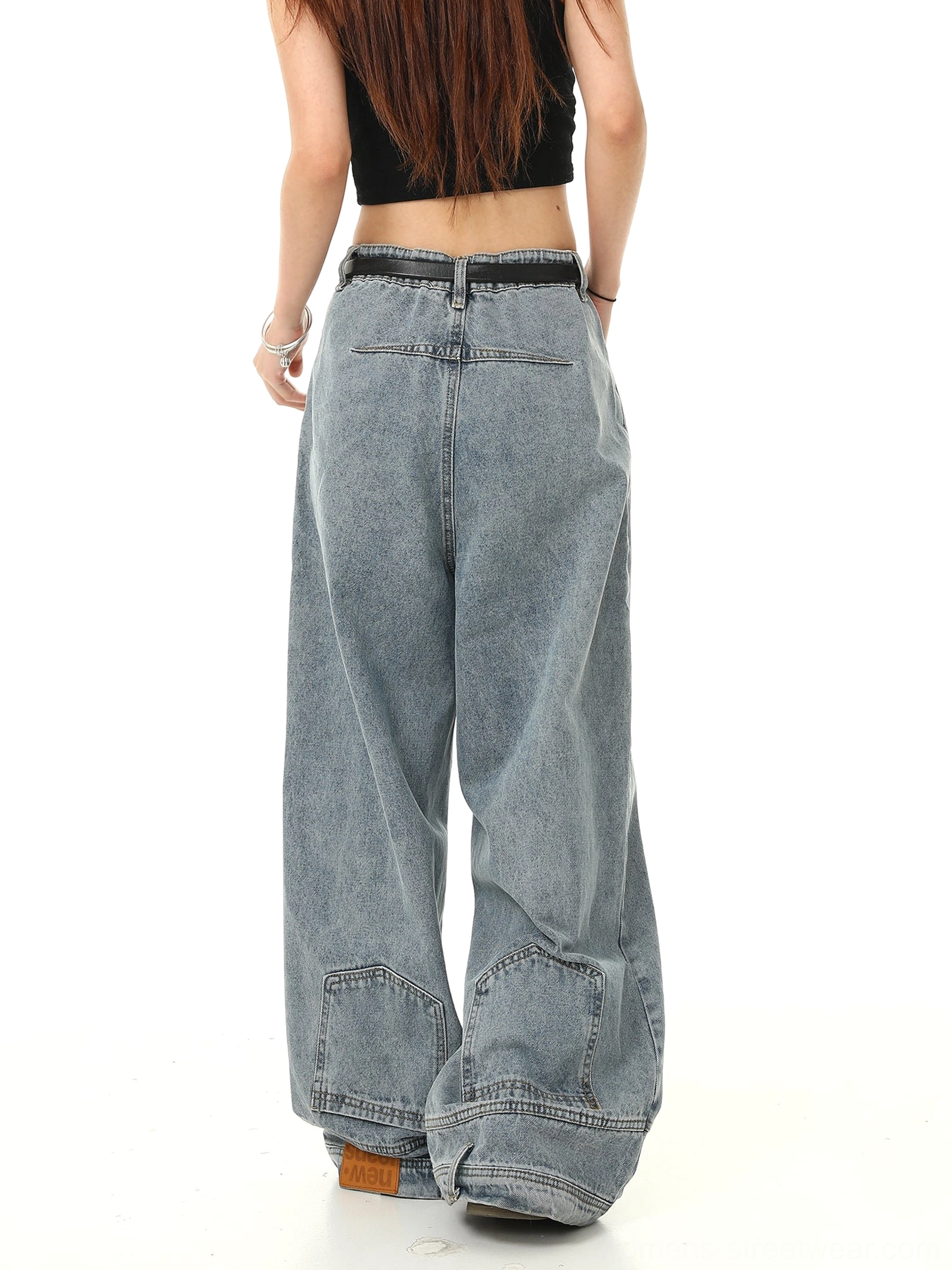 Back view of light blue washed wide-leg baggy jeans showing rear patch pockets, long hem, high waist, and relaxed Y2K denim silhouette