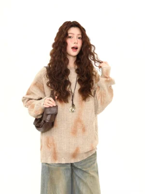Light brown oversized distressed tie-dye cable knit sweater worn with wide-leg jeans in front three-quarter streetwear look